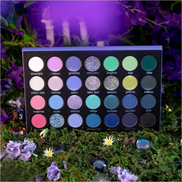 Jolie Beauty Ethereality eyeshadow palette with all shades displayed among flowers and moss.